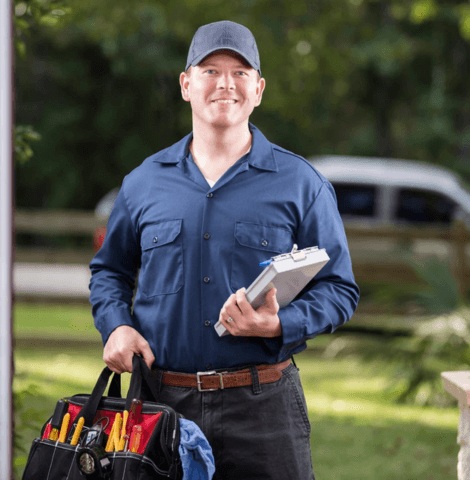 Technician in uniform greeting customer at the door for home repair service